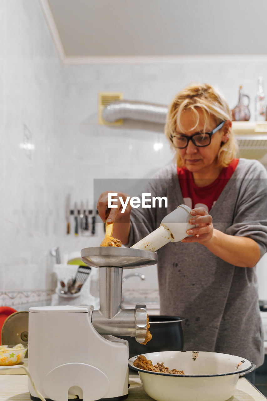 Mature woman preparing food at kitchen