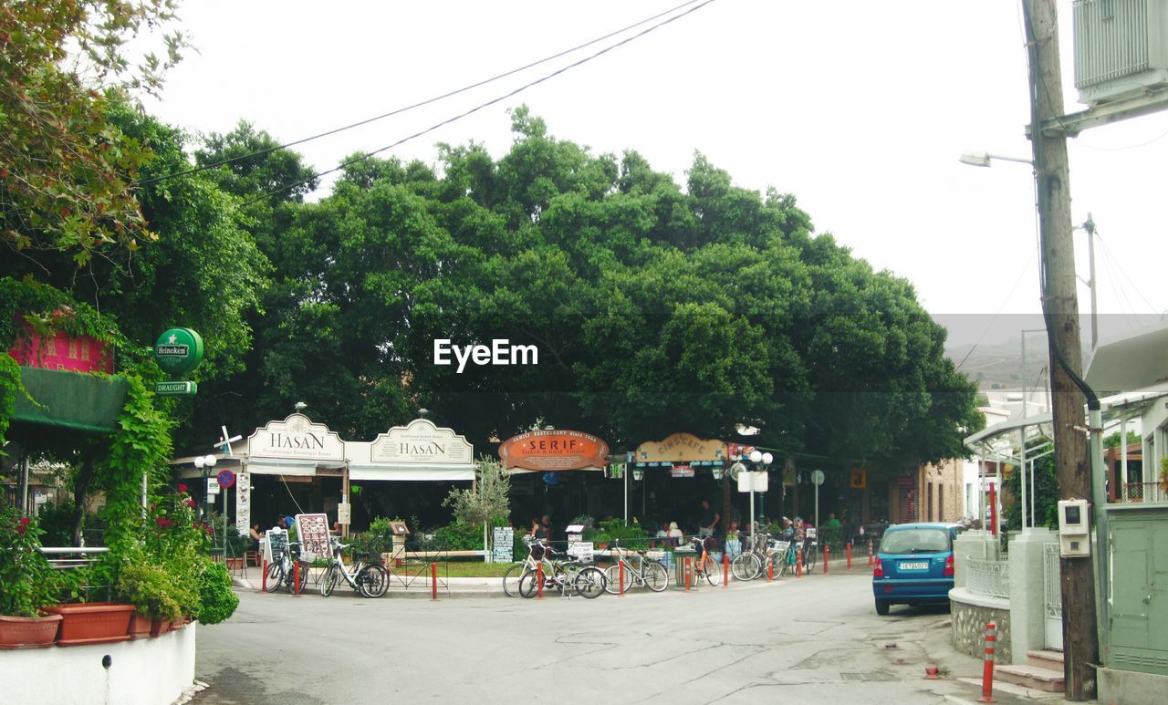 CARS ON STREET AMIDST BUILDINGS AGAINST SKY