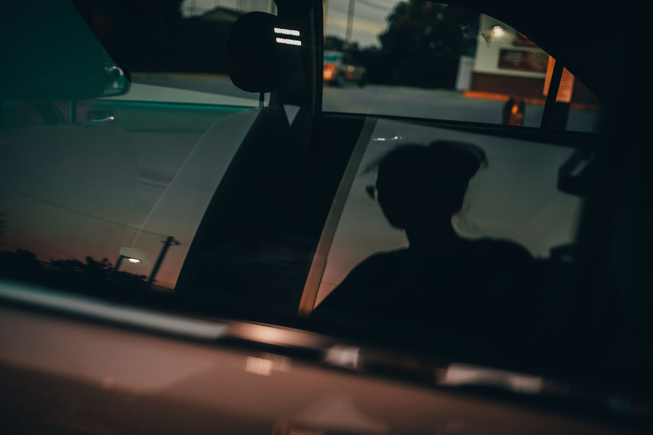 Close-up of woman reflecting on car window