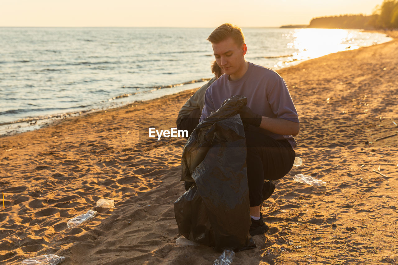 rear view of woman sitting on beach