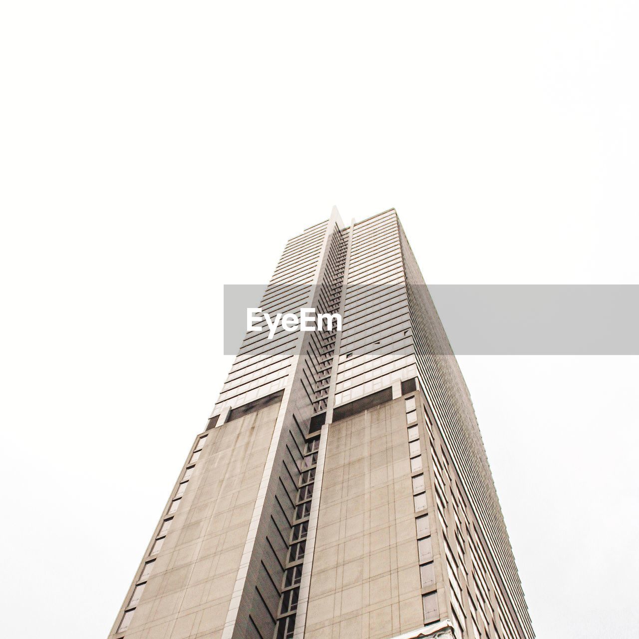 LOW ANGLE VIEW OF GLASS BUILDING AGAINST CLEAR SKY