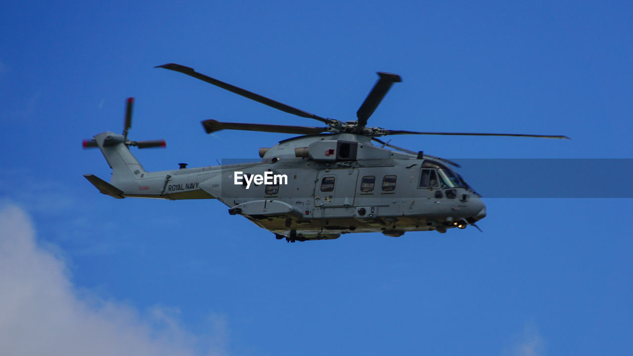LOW ANGLE VIEW OF HELICOPTER FLYING IN SKY