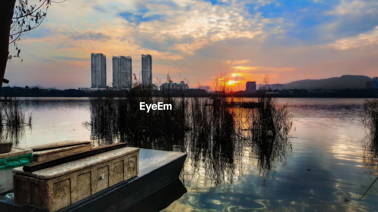 REFLECTION OF SKY IN LAKE AT SUNSET