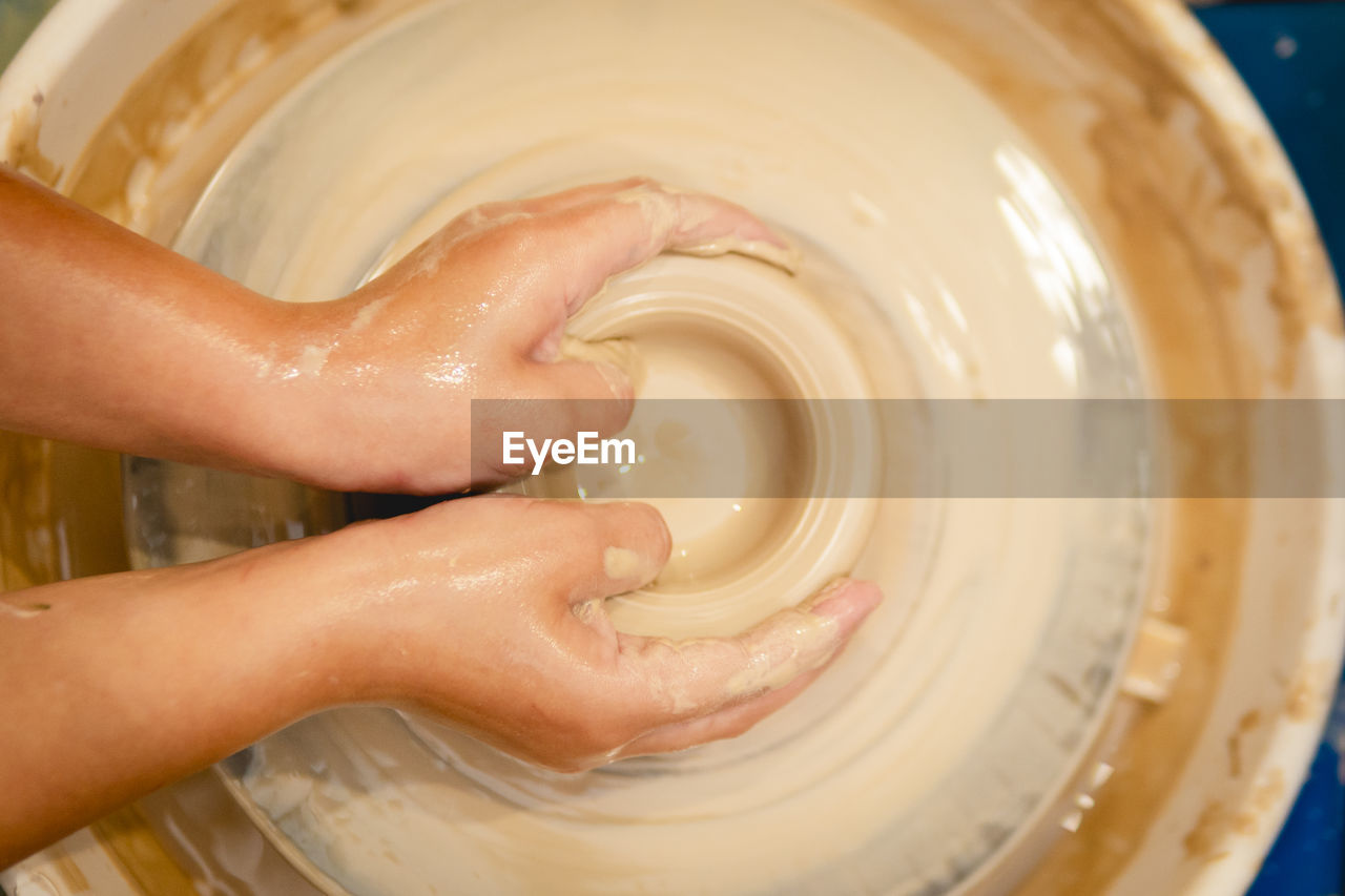 HIGH ANGLE VIEW OF PERSON HAND IN CONTAINER