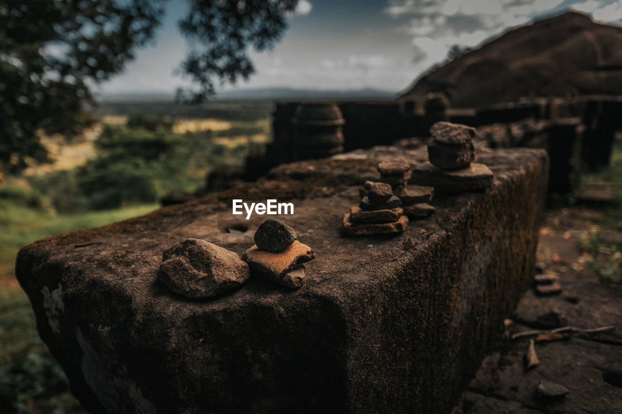 CLOSE-UP OF STONE STACK ON ROCK AT FIELD