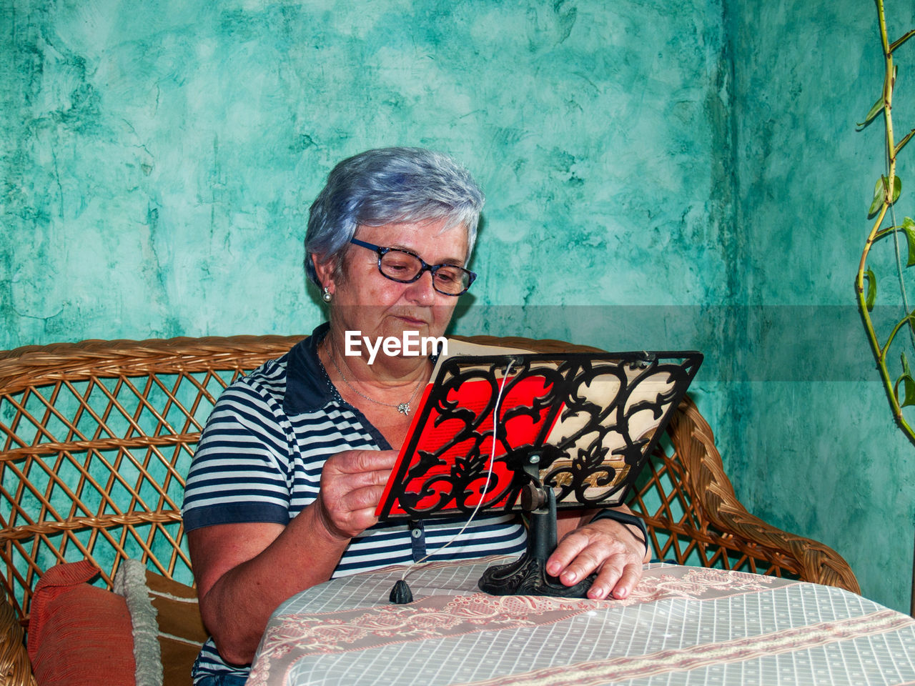 Woman reading book while sitting on sofa at home