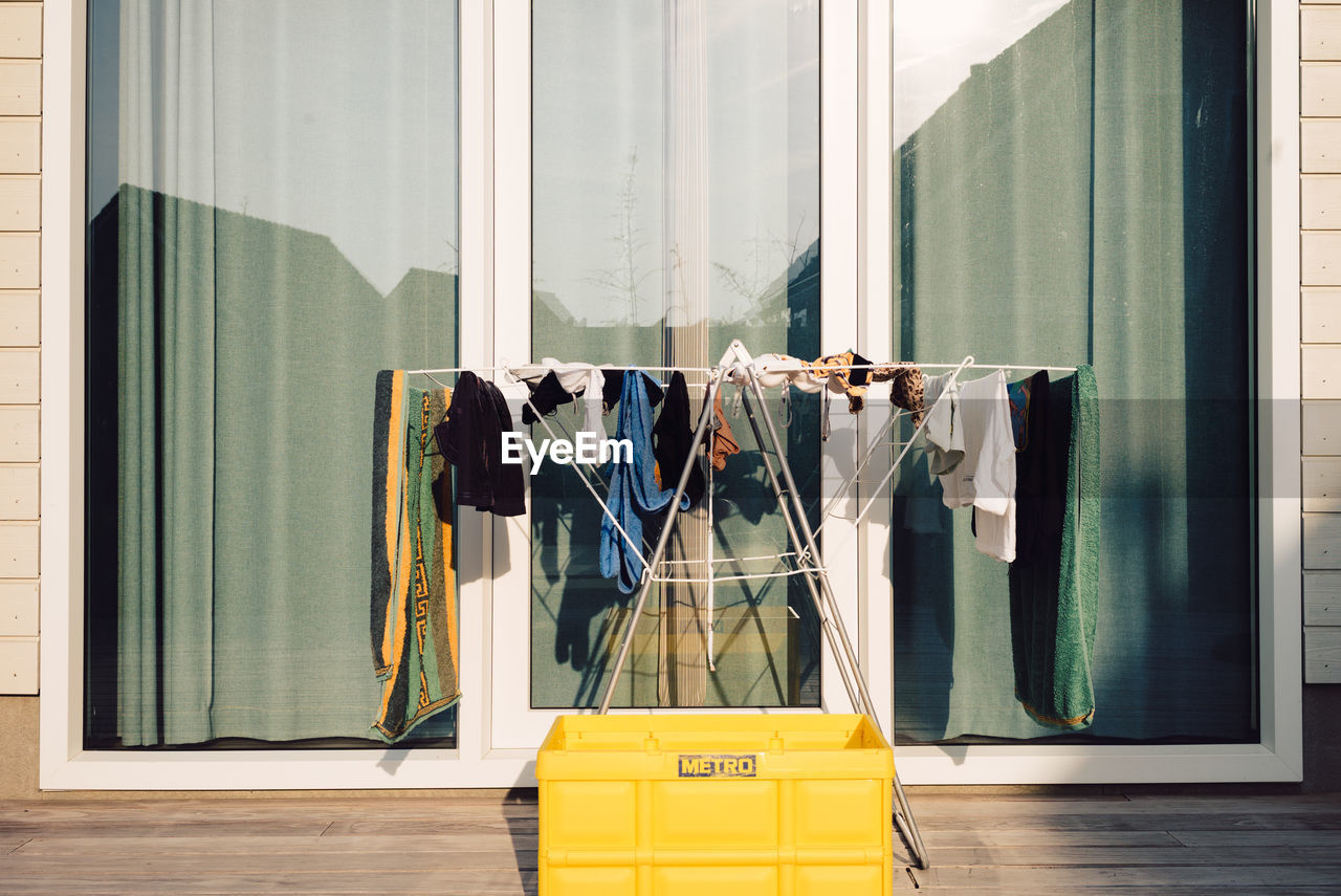 CLOTHES DRYING AGAINST WINDOW OF BUILDING