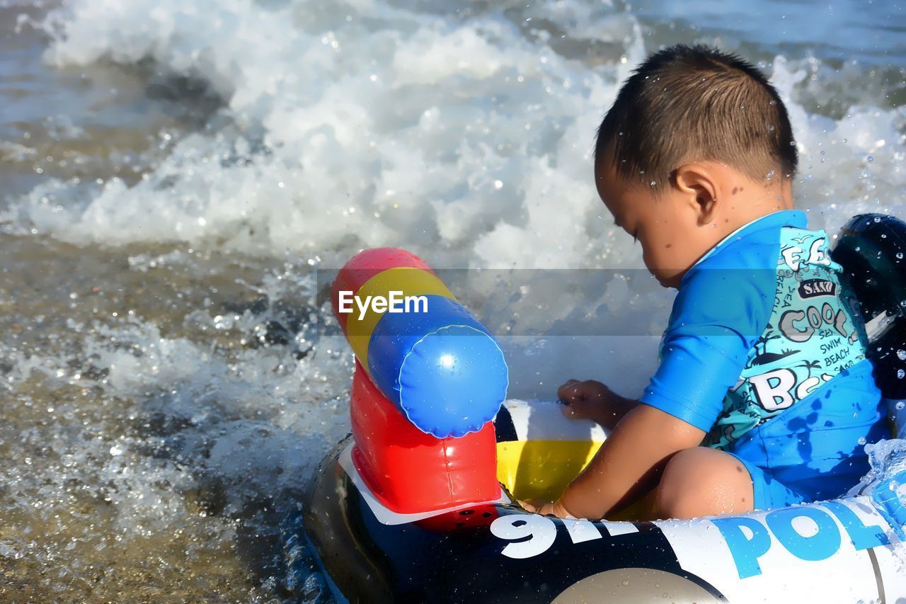 Boy sitting in inflatable ring at beach