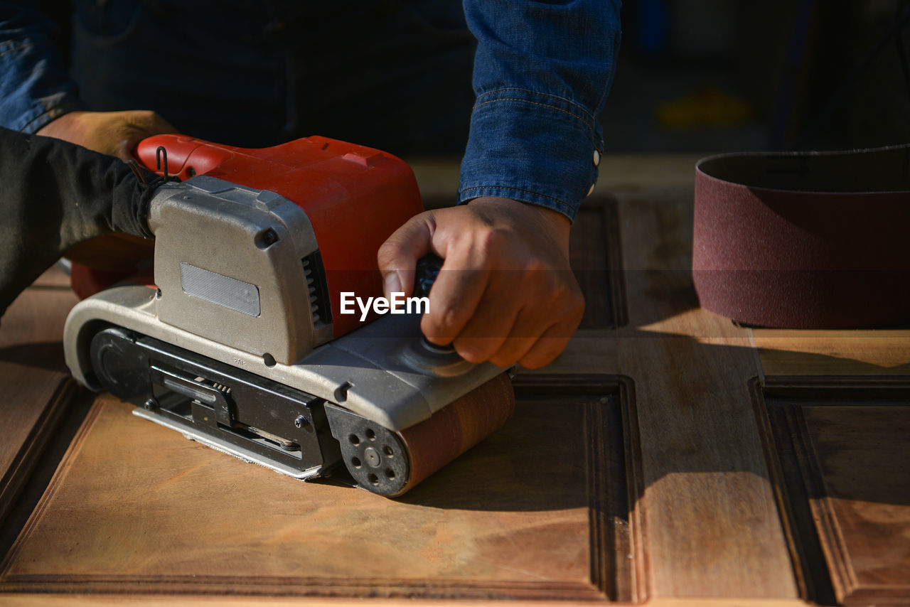 Close-up of man using smart phone on table