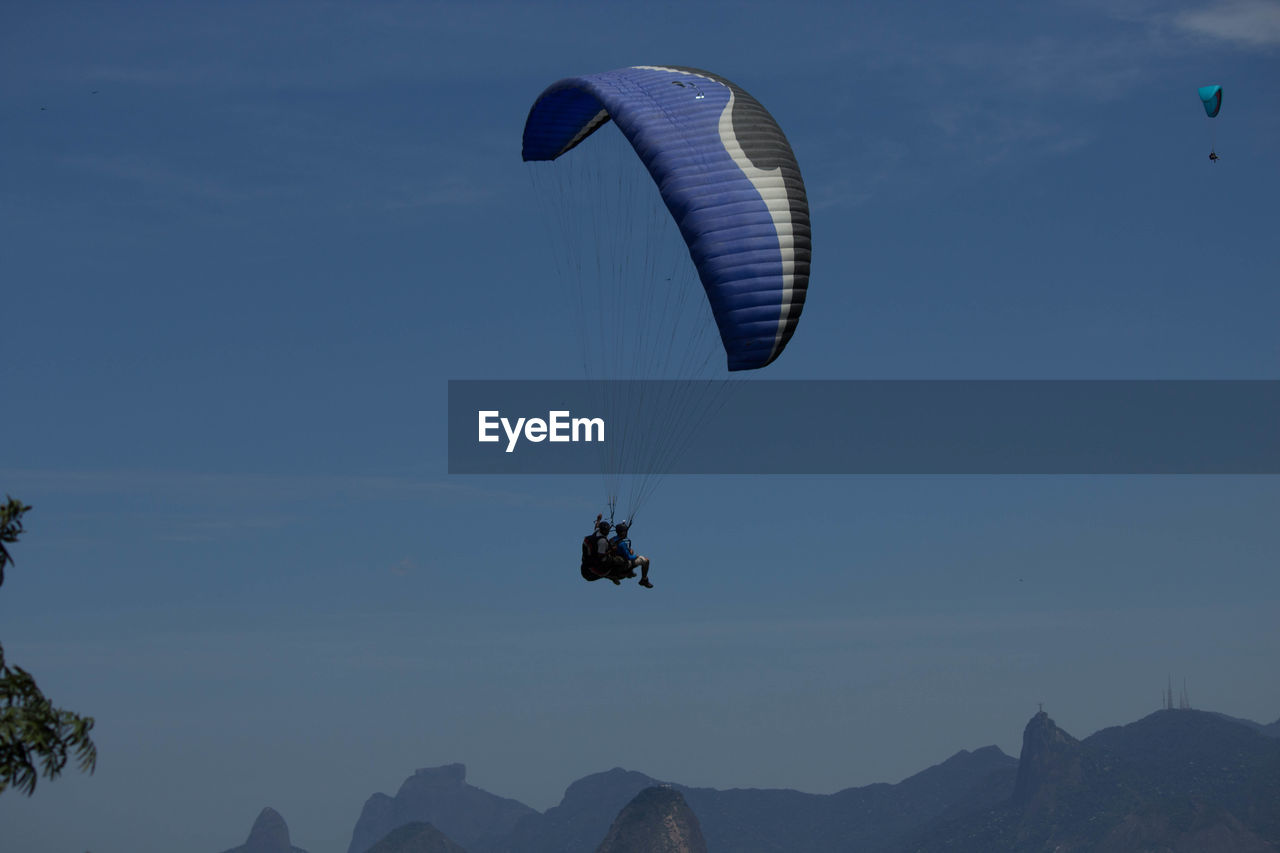 Low angle view of person paragliding against sky