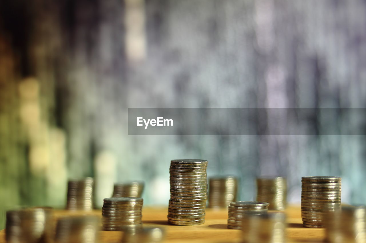 Stacked coins against binary code on screen