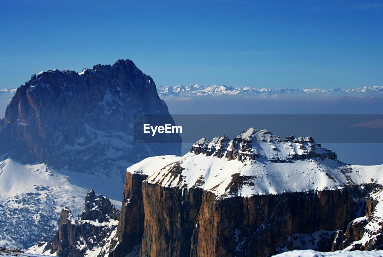 Scenic view of snow covered rocky mountains against sky