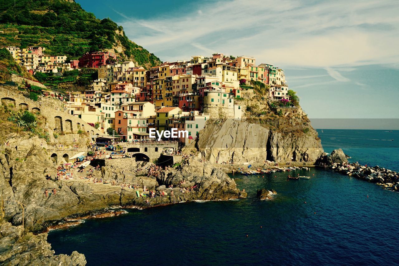 Scenic view of town by sea against sky