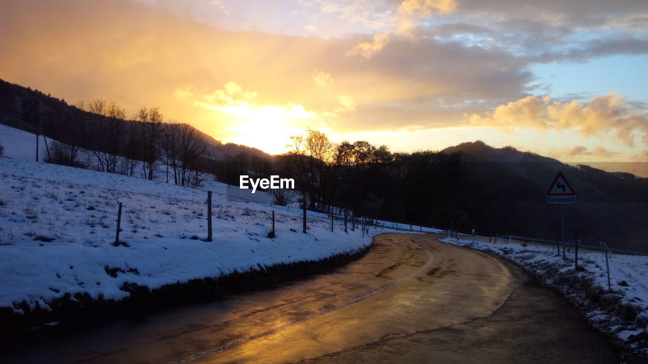 SNOWCAPPED LANDSCAPE AGAINST SKY DURING SUNSET