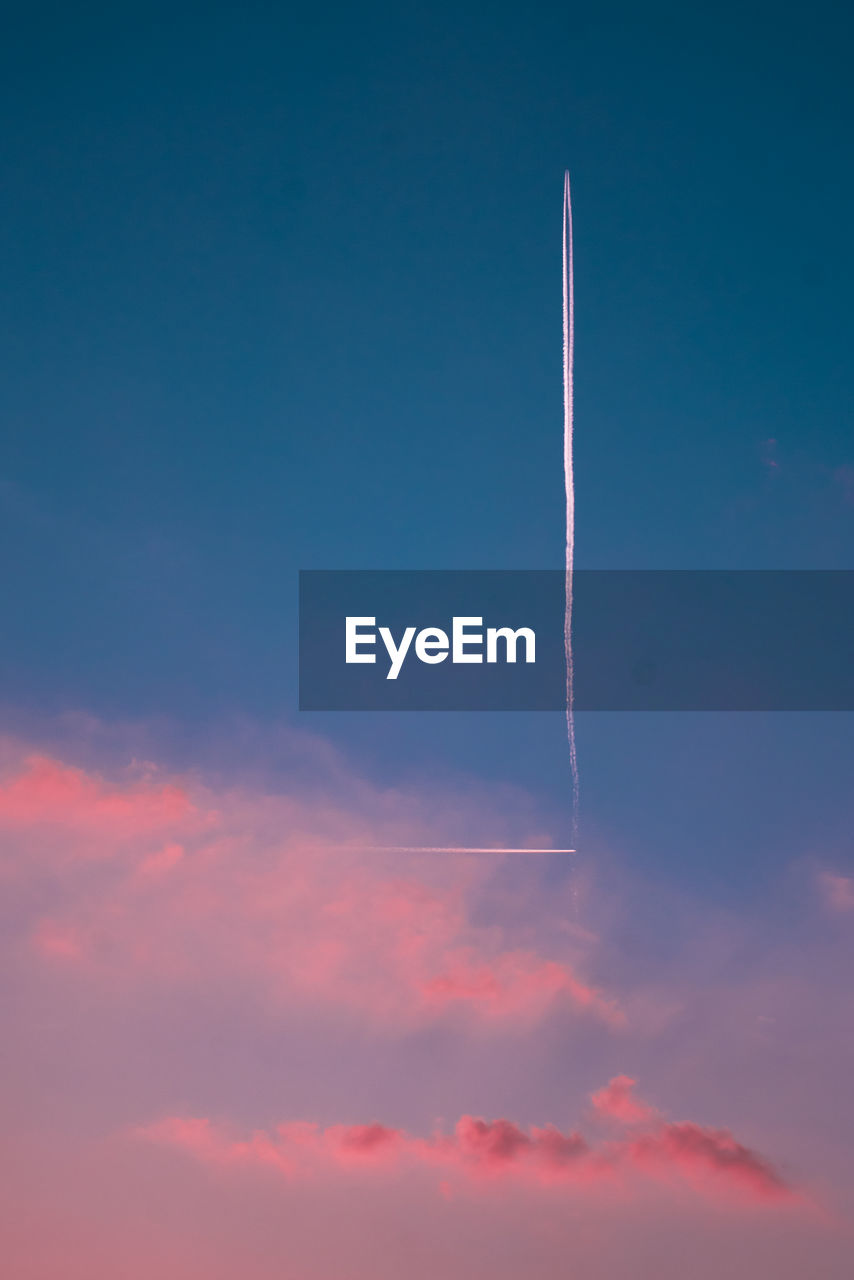 Low angle view of vapor trail against blue sky