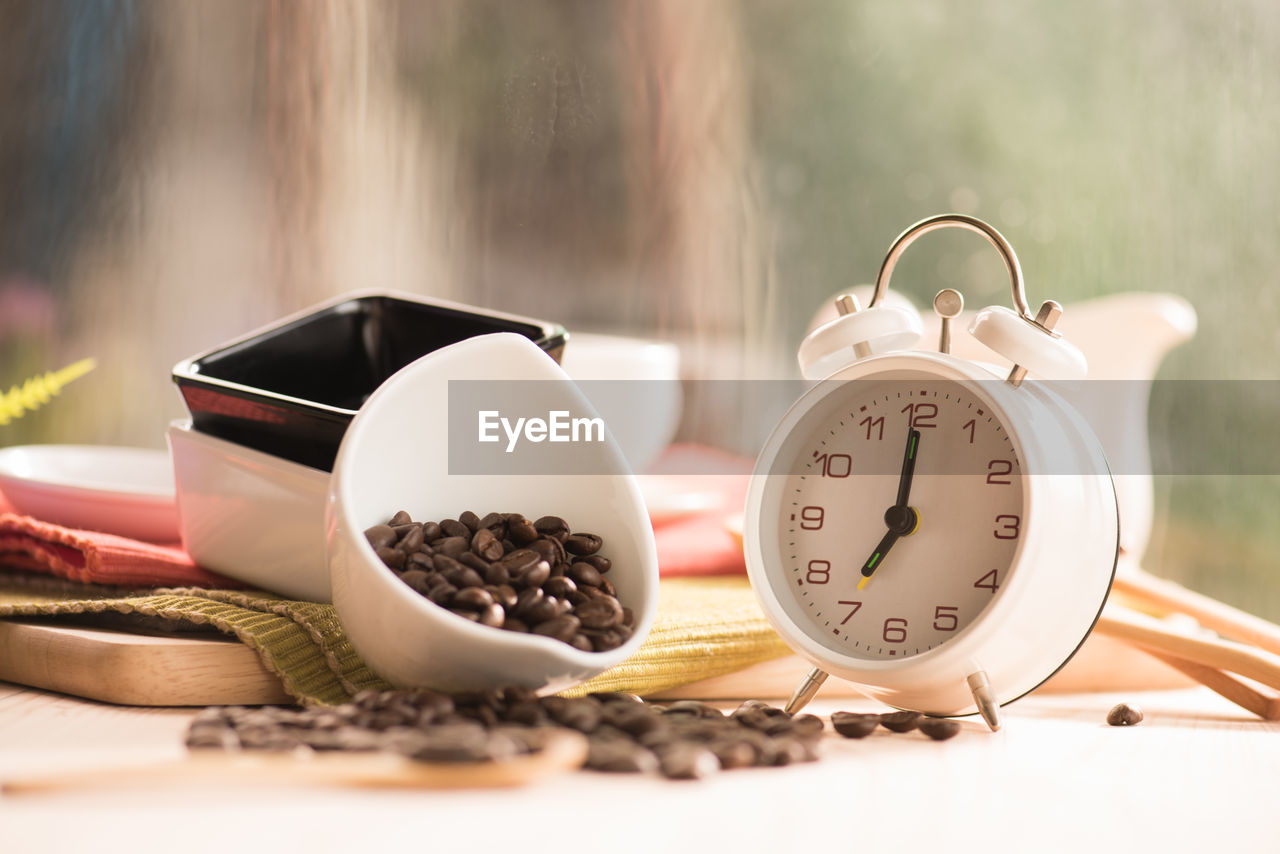 CLOSE-UP OF CLOCK ON TABLE IN KITCHEN
