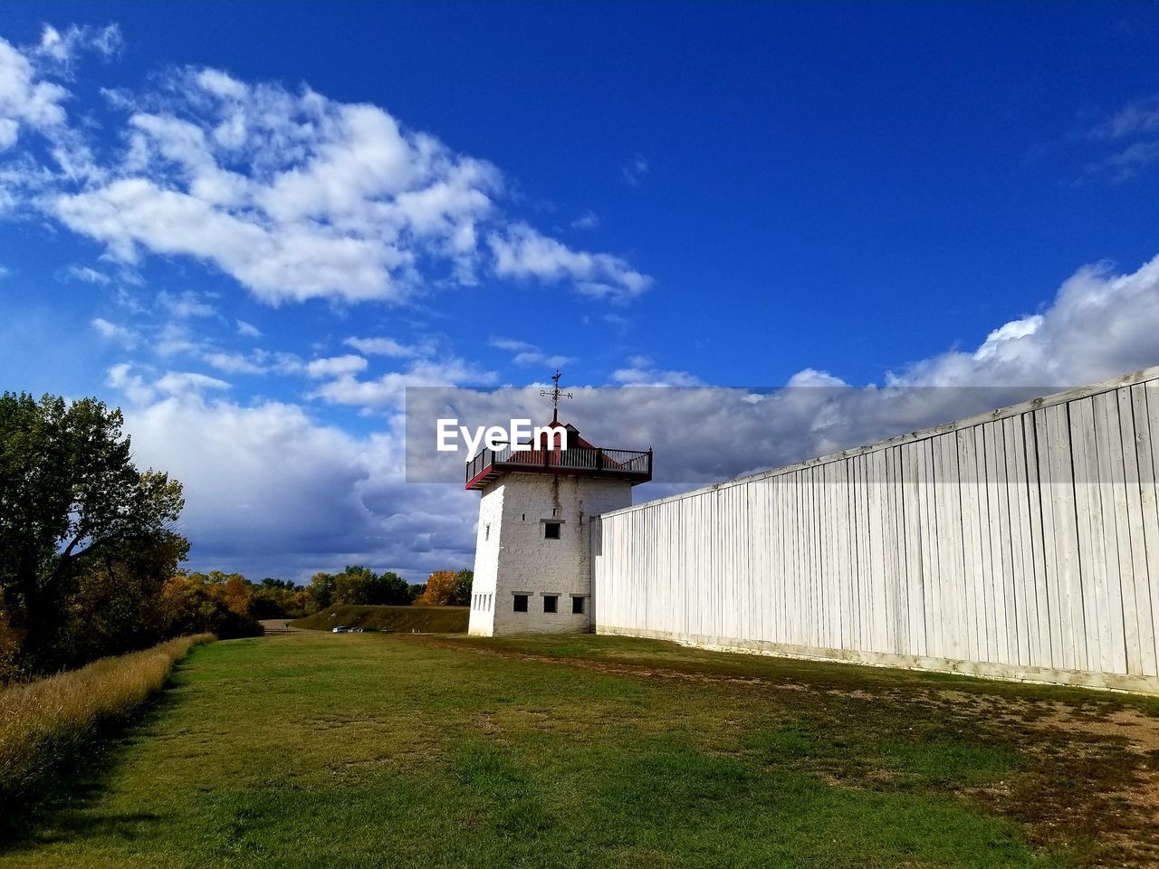 BUILDING ON FIELD AGAINST SKY