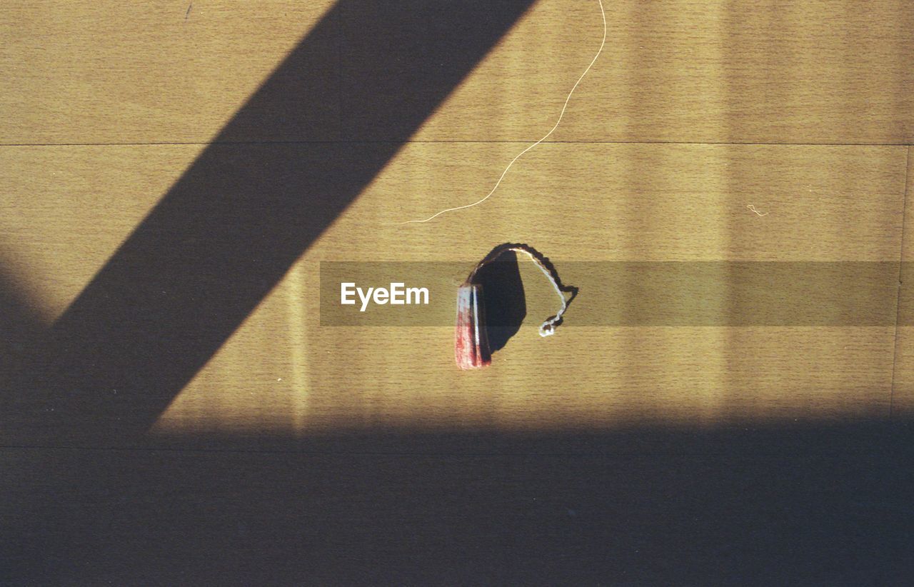 Directly above view of blood stained tampon on wooden table