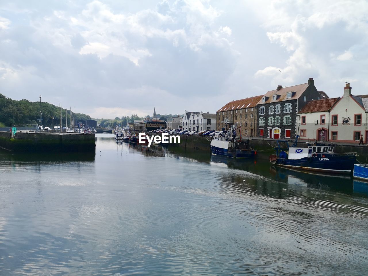 RIVER AMIDST BUILDINGS AGAINST SKY