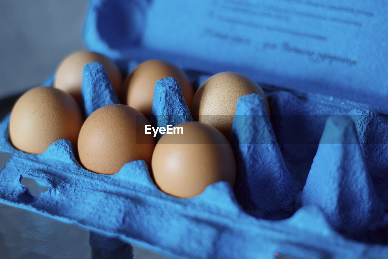 CLOSE-UP OF EGGS ON BLUE TABLE