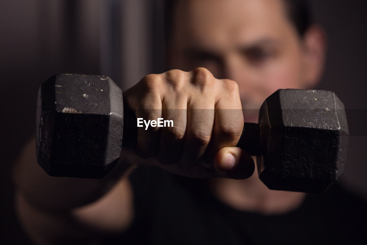 Close-up of man lifting dumbbell