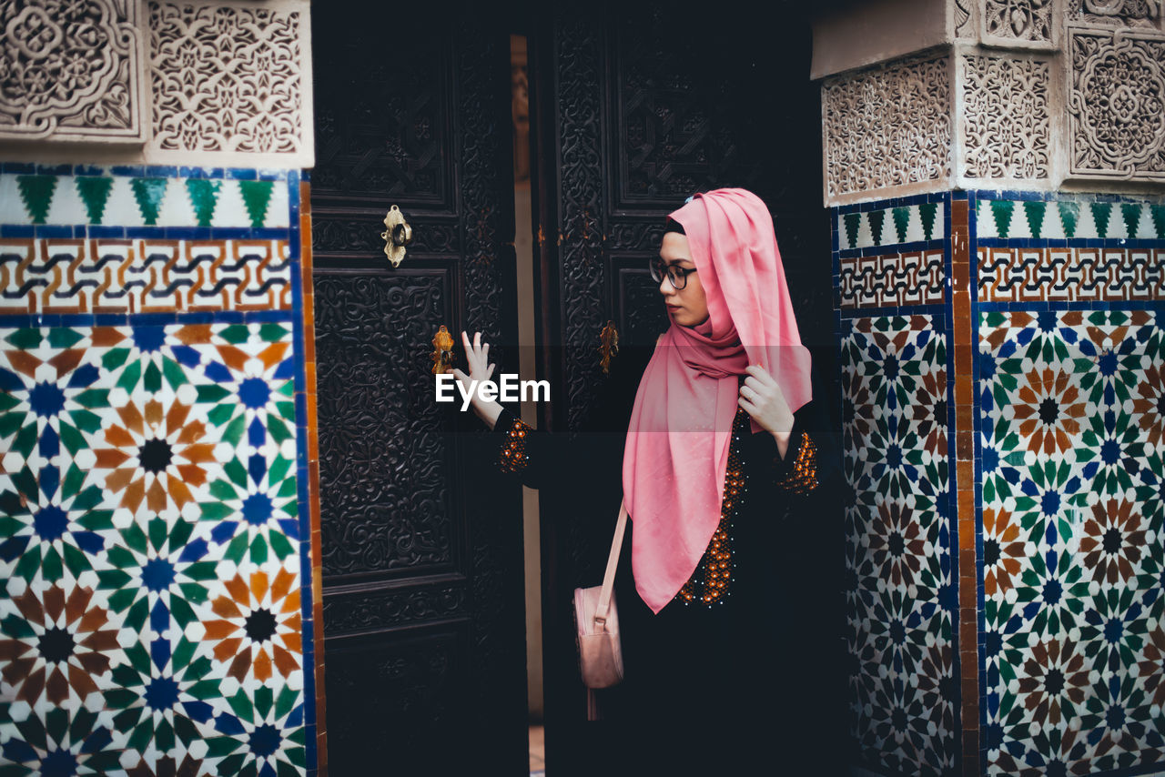 Woman standing at entrance of historic building