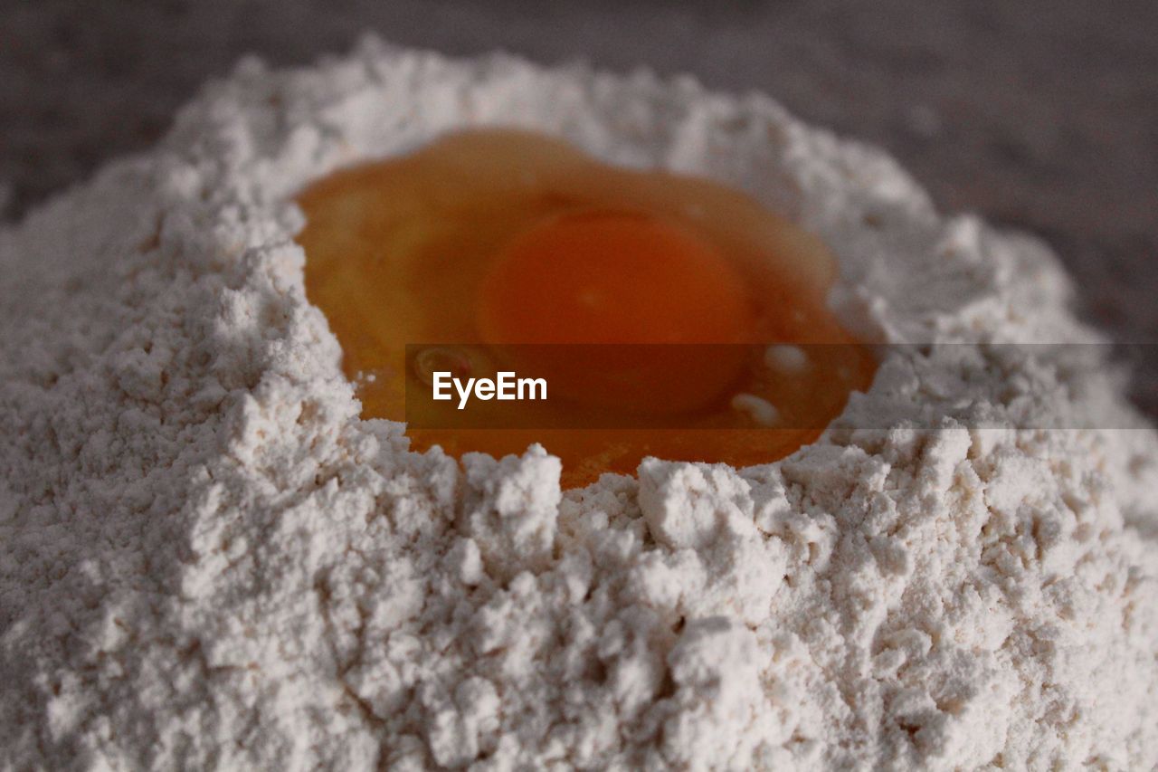 Close-up of egg yolk in flour