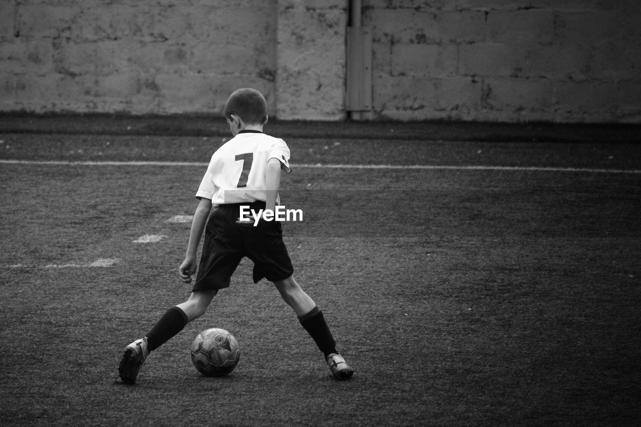 Rear view of boy playing soccer 