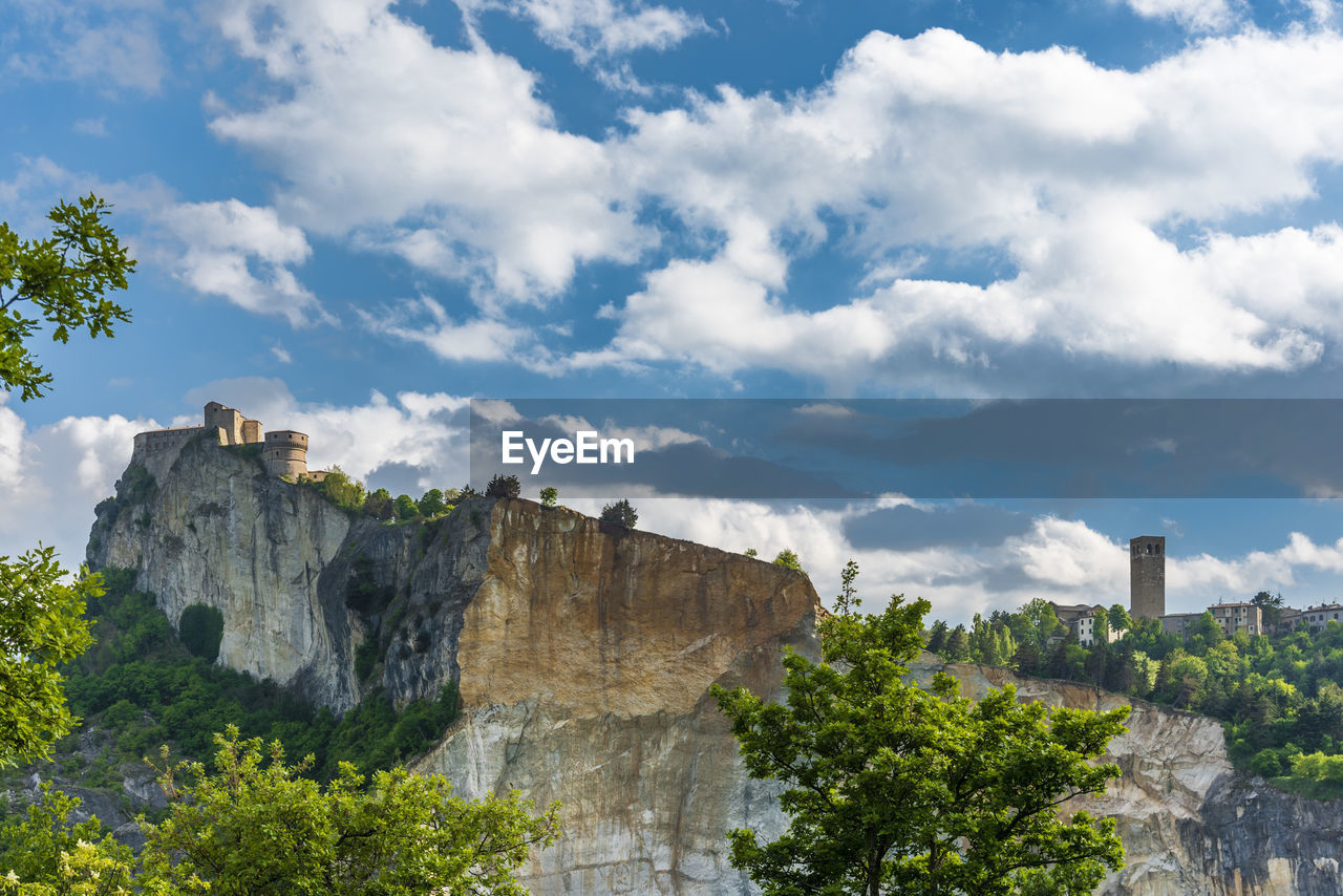 Rock formations on mountain against cloudy sky