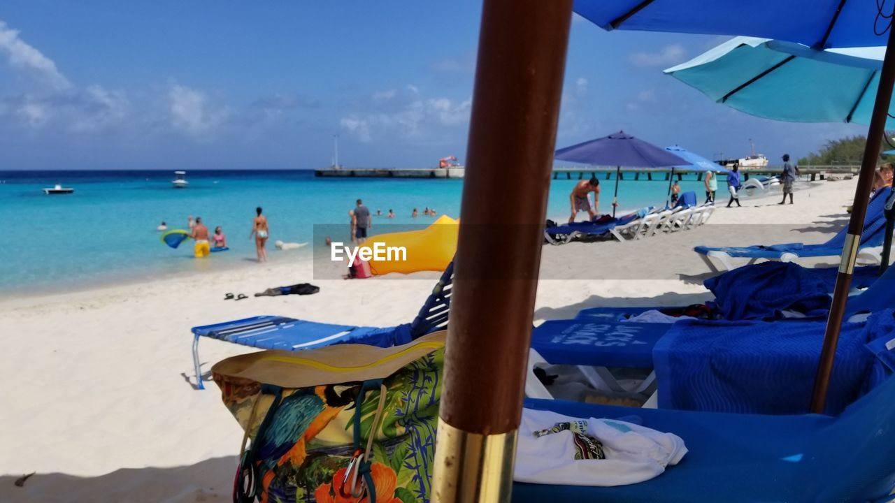 PEOPLE ON BEACH AGAINST BLUE SKY