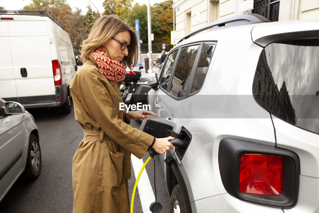 Woman charging electric car