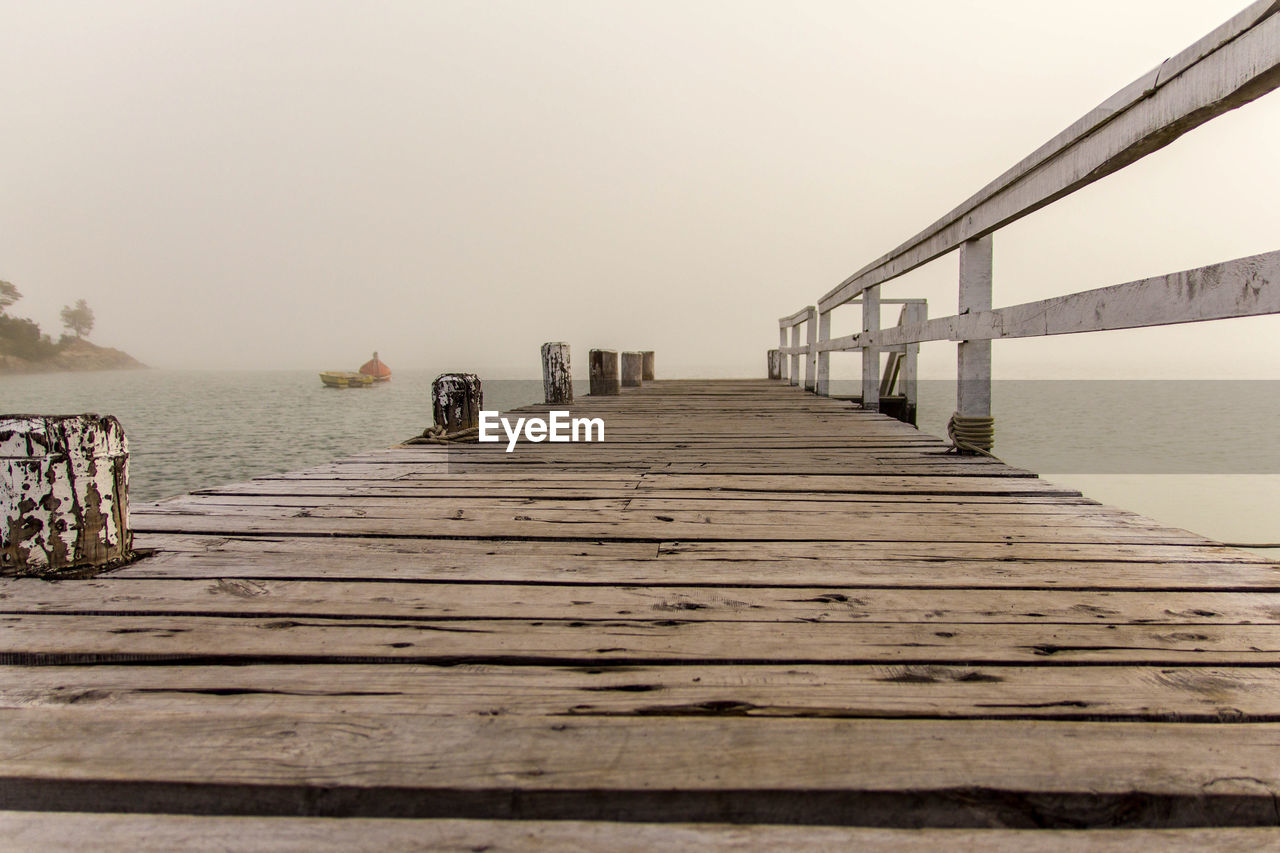 PIER AMIDST SEA AGAINST CLEAR SKY