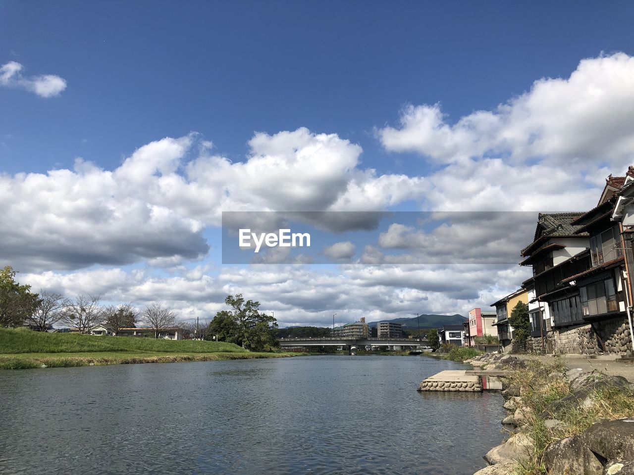 River by buildings against sky