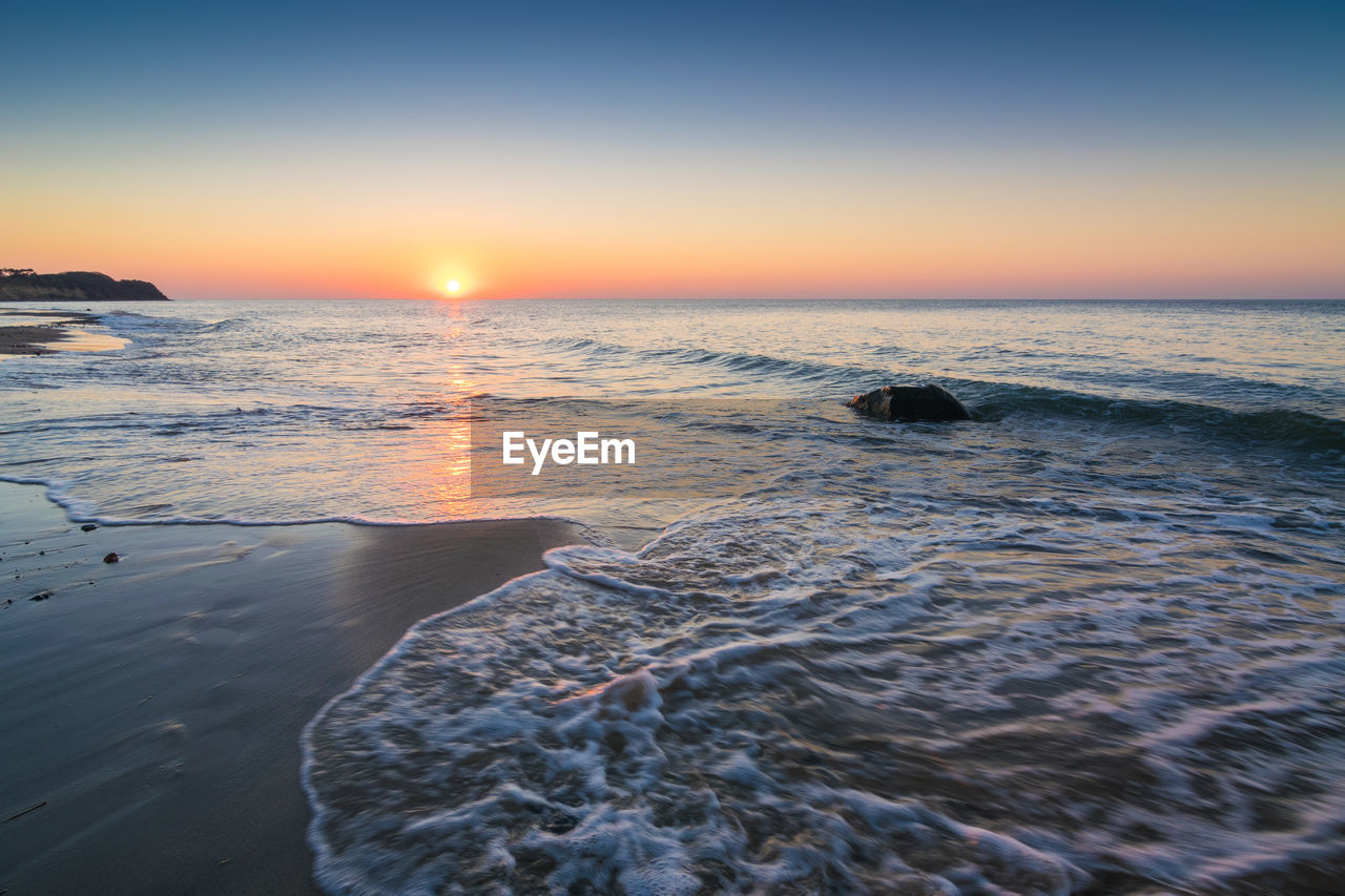 SCENIC VIEW OF BEACH DURING SUNSET