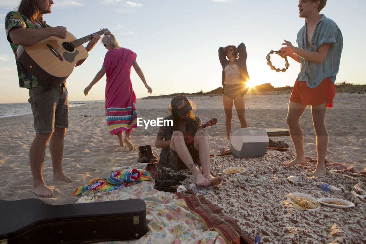 Friends playing music together on a beach