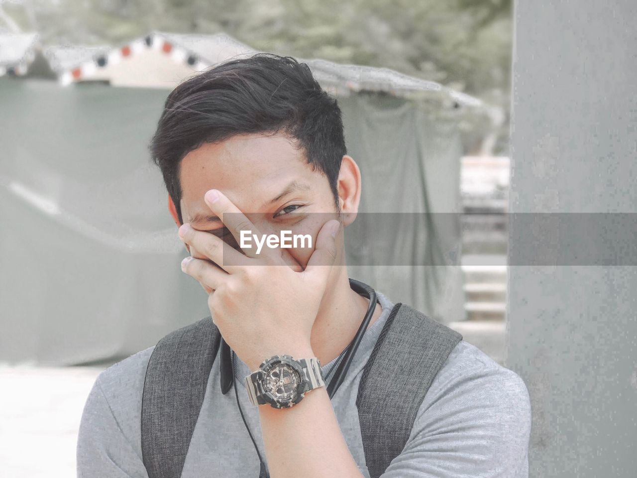 Portrait of young man covering face