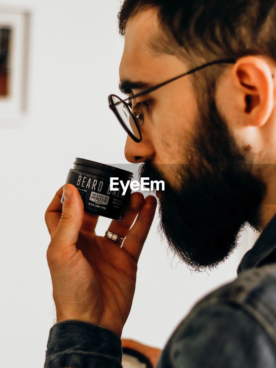 CLOSE-UP PORTRAIT OF YOUNG MAN WEARING EYEGLASSES HOLDING DRINKING GLASSES