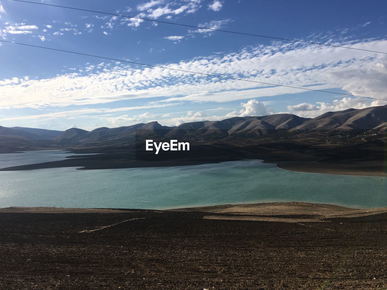 Scenic view of lake by mountains against sky