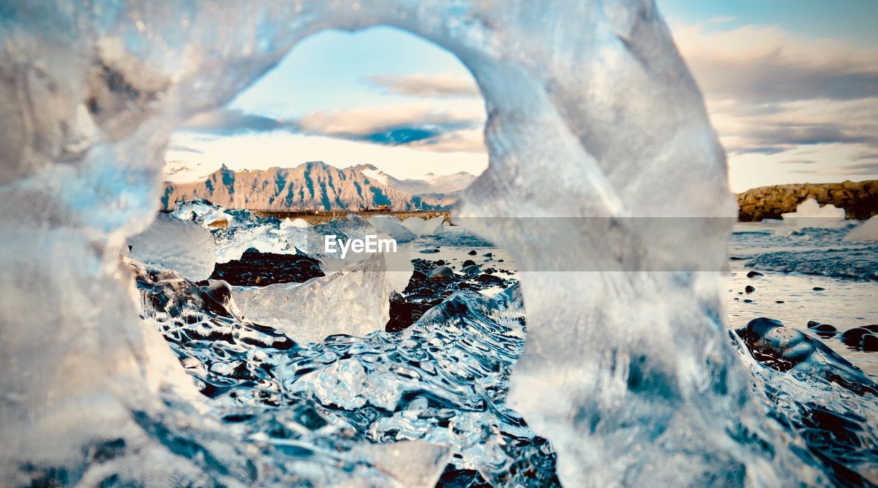 PANORAMIC VIEW OF FROZEN LAKE AGAINST SKY