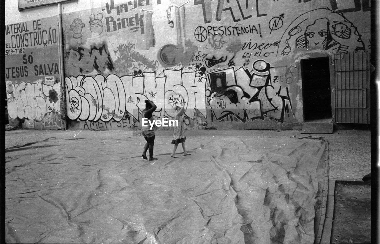 YOUNG WOMAN WALKING ON SIDEWALK