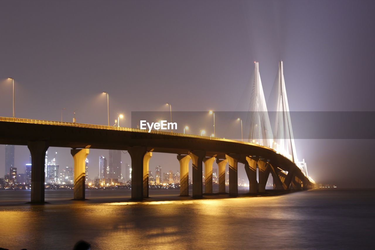 Bridge over calm lake at night