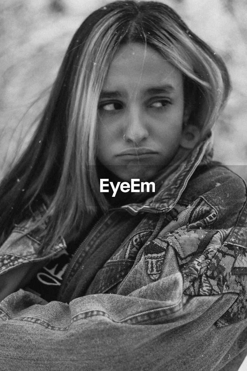 Girl making face while standing outdoors during winter