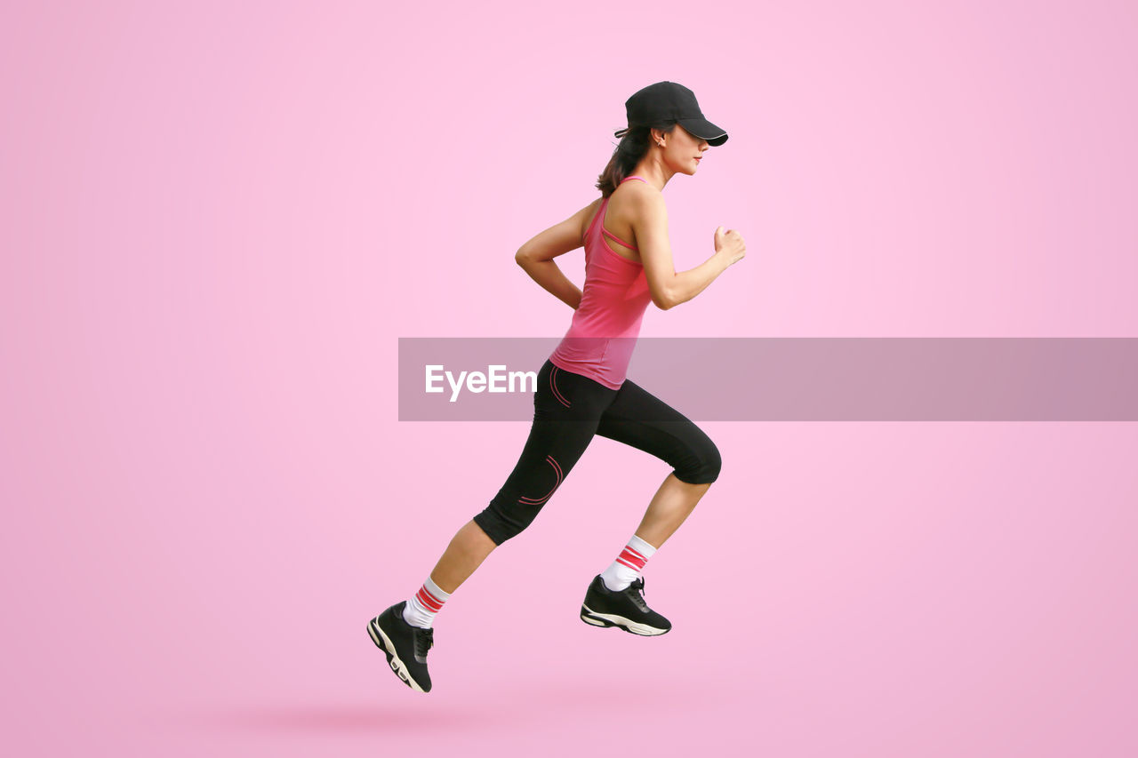 rear view of young woman exercising against white background