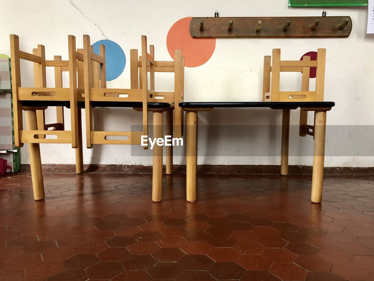 Empty chairs and table against wall