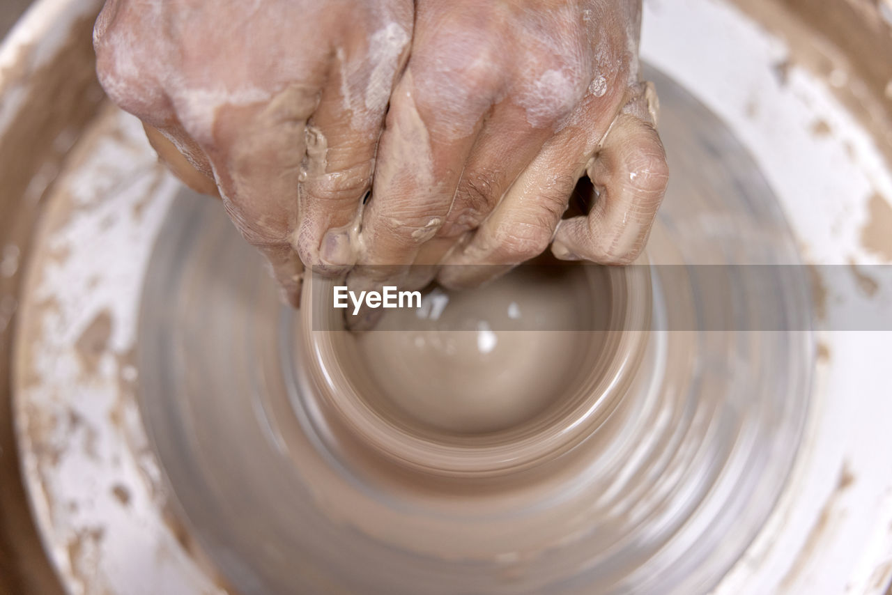 cropped image of person making pottery
