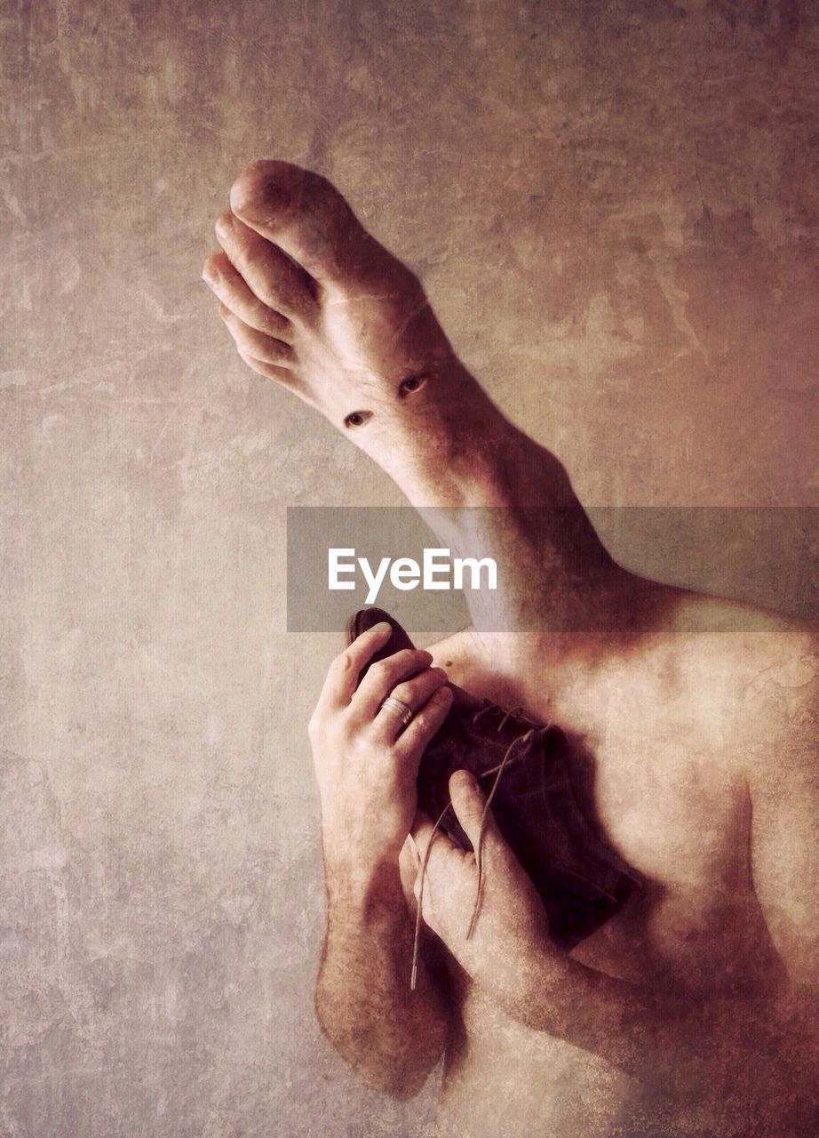 Man with foot instead of head holding shoe