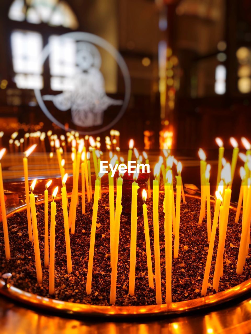 CLOSE-UP OF ILLUMINATED CANDLES IN BUILDING