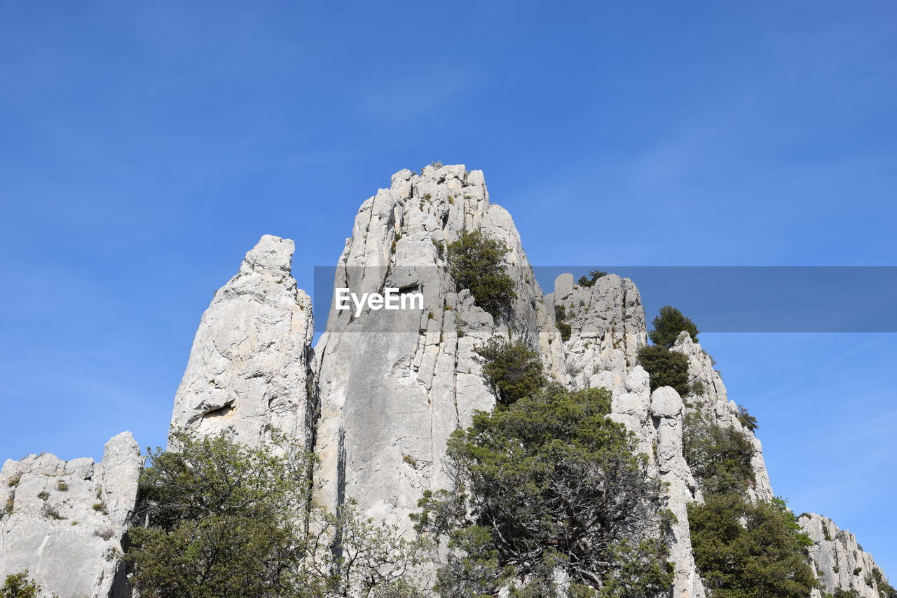 Low angle view of rocks against blue sky