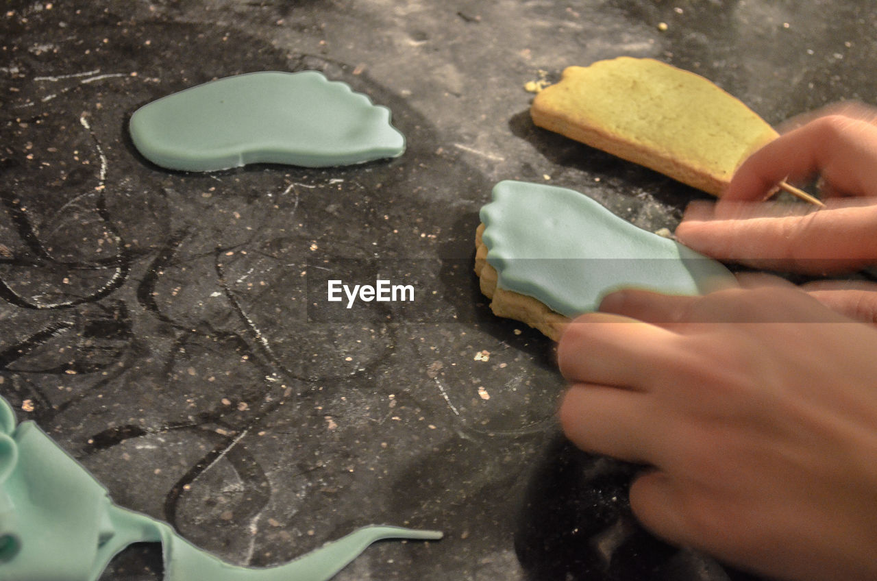 Cropped image of hands preparing biscuits at table
