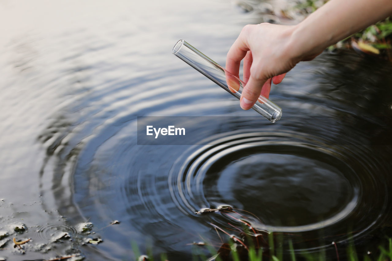 Scientist and biologist hydro-biologist takes water samples for analysis. hand is collects water in